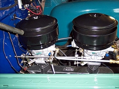  Most intake/exhaust parts came from Patrick's or Tom Langdon.  A 60s Camaro throttle rod was adapted from the accelerator bell-crank to the carburetors' linkage.  The original AC glass-bowl fue filter is at the inlet side of the fuel pump.  Oil bath air cleaners have been adapted for the Carter-Weber base and have modern paper-element filters.  Intake and exhaust manifolds and carb adapters have been coated with Calyx dressing.